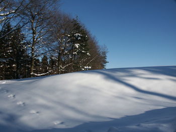 Scenic view of snow covered landscape against clear sky