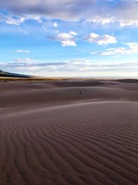 View of desert against cloudy sky