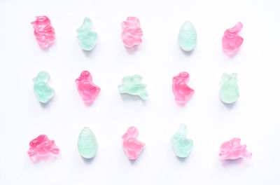 High angle view of multi colored candies against white background