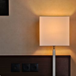 Low angle view of illuminated lamp on table against wall at home