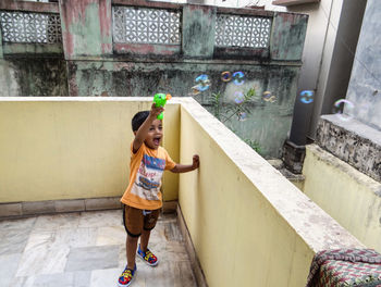Boy playing with bubbles on terrace