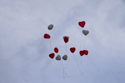 Low angle view of balloons flying against sky