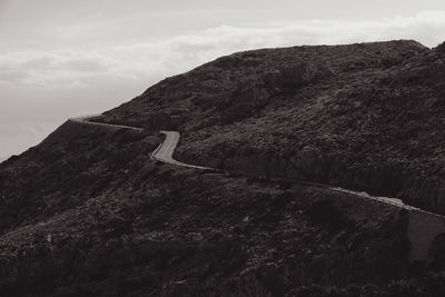 Road on tree mountain against sky