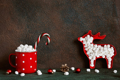 Christmas or new year greeting card. red cocoa mug and deer with marshmallows 