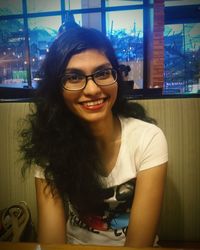 Portrait of smiling young woman sitting at home