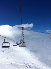 Ski lift over snowcapped mountain against sky