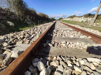 Railroad track amidst rocks against sky