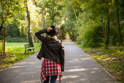 Rear view of woman standing in forest