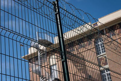 Low angle view of buildings seen through fence