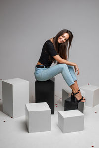 Portrait of a smiling young woman against wall