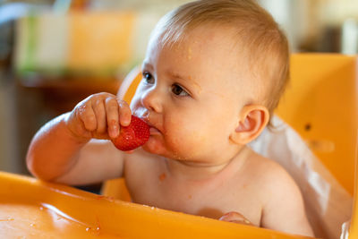 Cute baby girl eating fruit