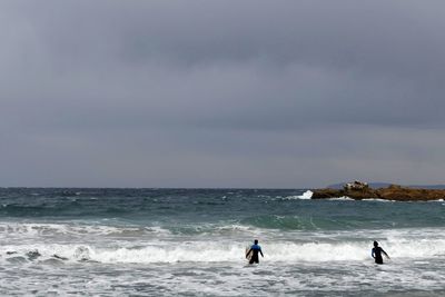 People on sea against sky