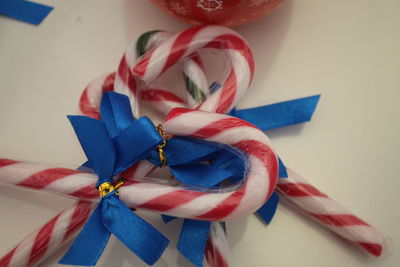 Close-up of candy canes with blue ribbons on table