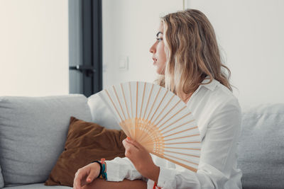 Side view of young woman with umbrella