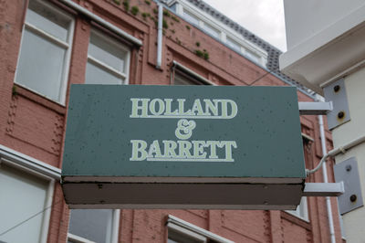 Low angle view of information sign on wall of building