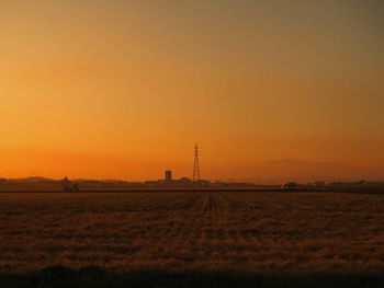 Scenic view of field against orange sky