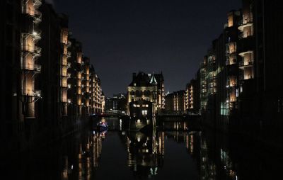 Canal passing through city buildings at night
