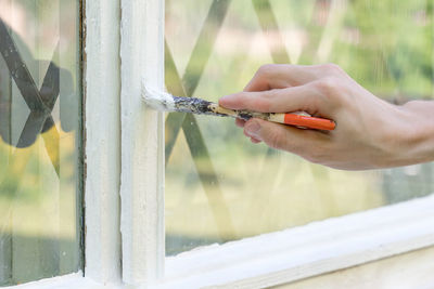 Cropped hand of person painting window sill 