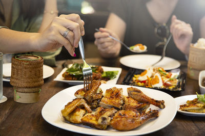 Close-up of hand holding food served on table