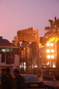 People at illuminated historical building against sky at night