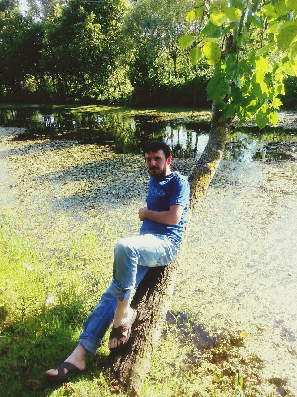 person, lifestyles, casual clothing, leisure activity, sitting, water, looking at camera, young adult, portrait, tree, full length, childhood, smiling, river, elementary age, relaxation, lake, sunlight