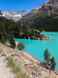 Scenic view of lake and mountains against blue sky