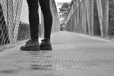 Low section of man standing on footbridge