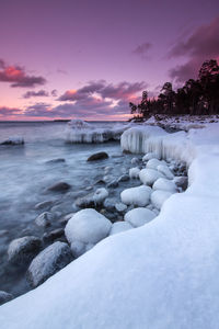 Scenic view of frozen seashore against dramatic sky