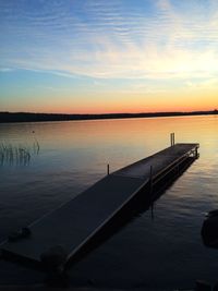 Pier on lake at sunset