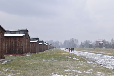 Houses on field against sky during winter