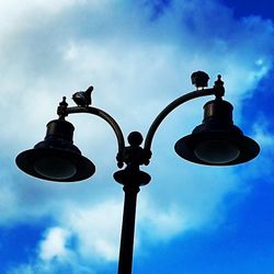 Low angle view of street light against blue sky