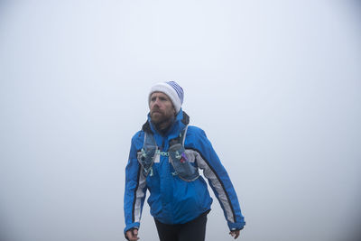 Man wearing sports clothing walking in foggy weather