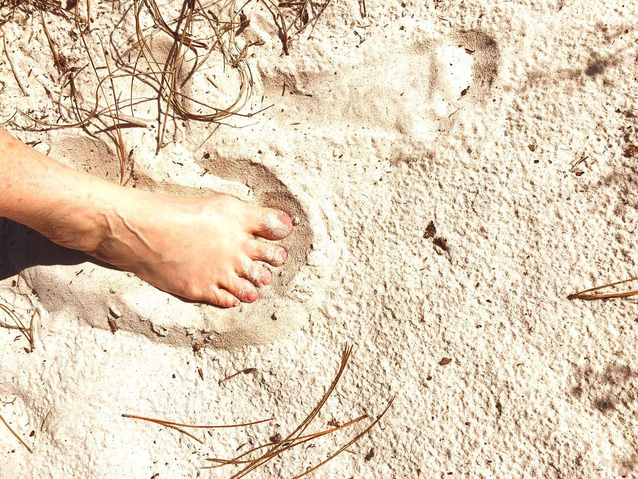 CLOSE-UP LOW SECTION OF PERSON ON SAND