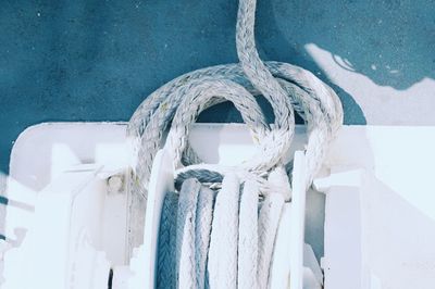 Close-up of rope rolled up on white spool on boat deck