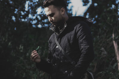 Man holding leaf in forest