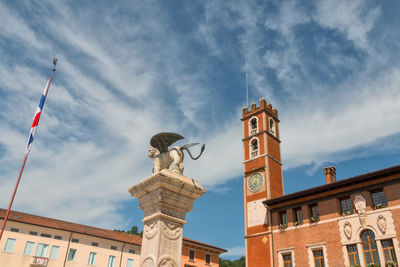 Low angle view of statue against building against sky