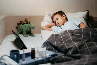 High angle view of woman using mobile phone on bed at home