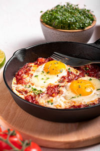 Traditional israel food eggs with tomatoes shakshouka in a pan close up