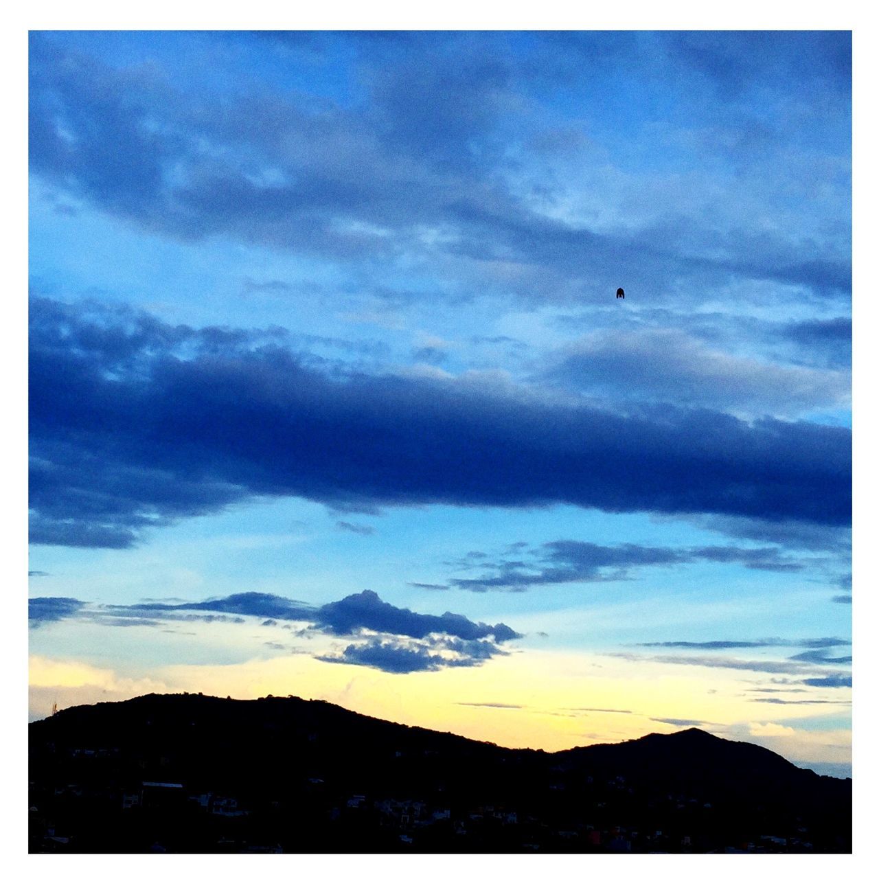 sky, silhouette, transfer print, cloud - sky, scenics, sunset, beauty in nature, auto post production filter, tranquil scene, cloud, tranquility, nature, dusk, cloudy, landscape, mountain, low angle view, outdoors, bird, animal themes