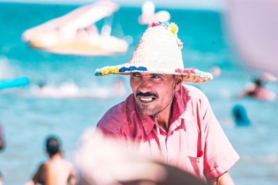 Portrait of man wearing hat against sea