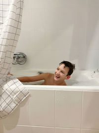 Smiling boy taking a bath