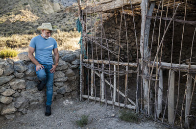 Adult man in cowboy hat and jean in a rural area