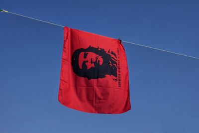 Low angle view of flag on rope against clear blue sky