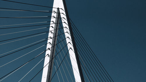 Low angle view of modern cable stayed bridge against clear blue sky