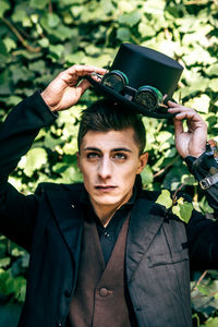 Portrait of young man holding plant