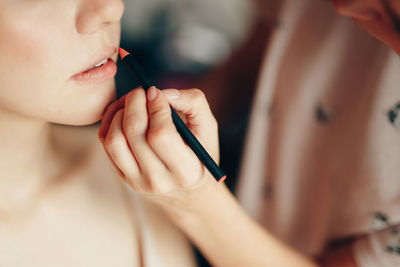 Midsection of beautician applying make-up