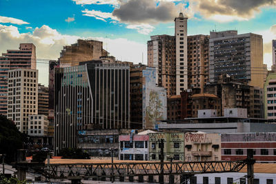 Buildings in city against cloudy sky