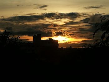 Silhouette buildings against sky during sunset