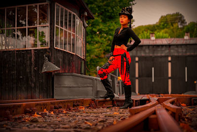 Portrait of man standing by leaves against building
