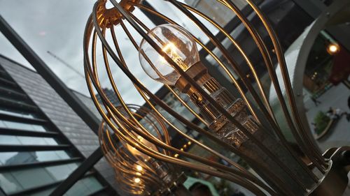 Low angle view of illuminated light bulbs in building